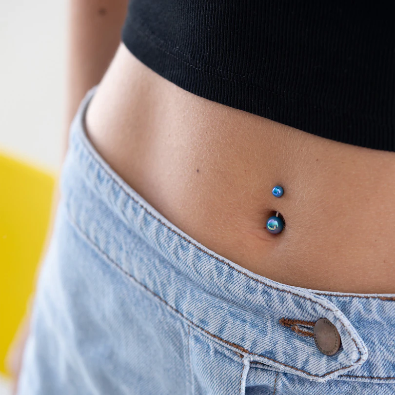 Navlepiercing med metalliske kuler