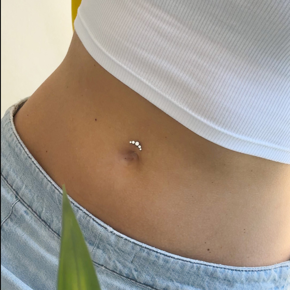 Svevende navlepiercing i titan med krystaller