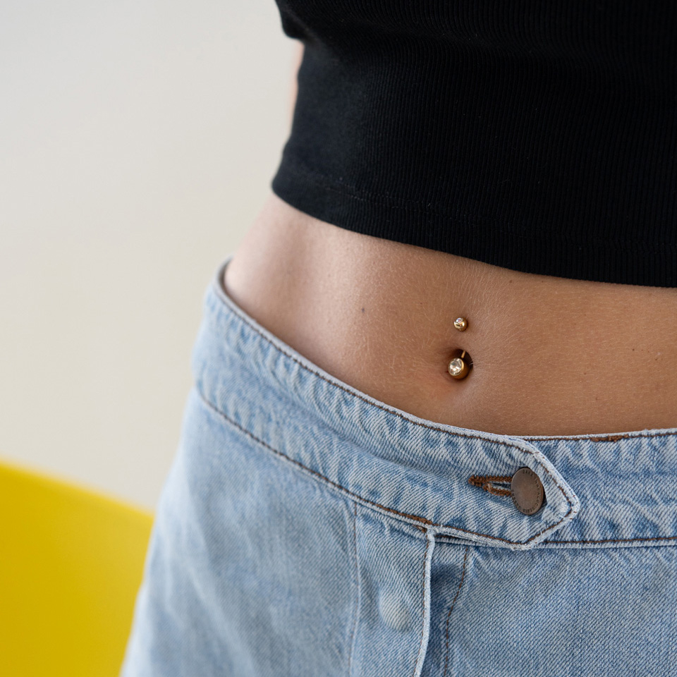 Gullbelagt navlepiercing med sten