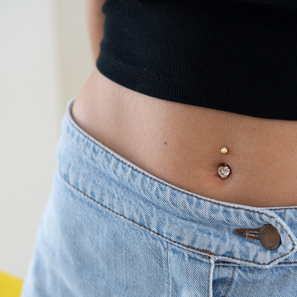 Navlepiercing i flere farger med hjertesten